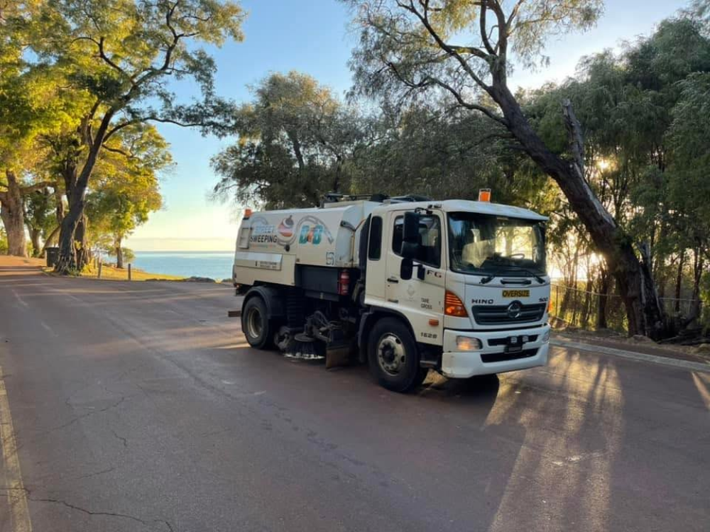 A white sweeper with 2 axles