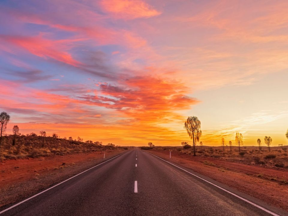 Desert road with a vibrant sunset sky in Australia