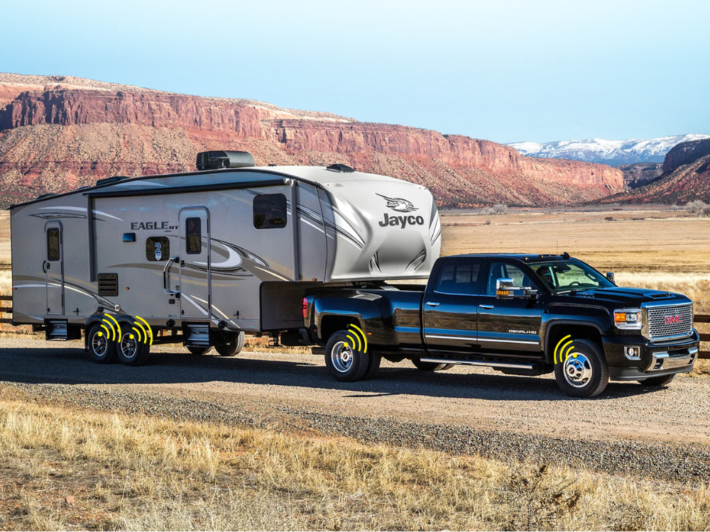 Black truck towing a travel trailer with desert landscape in the background in Australia