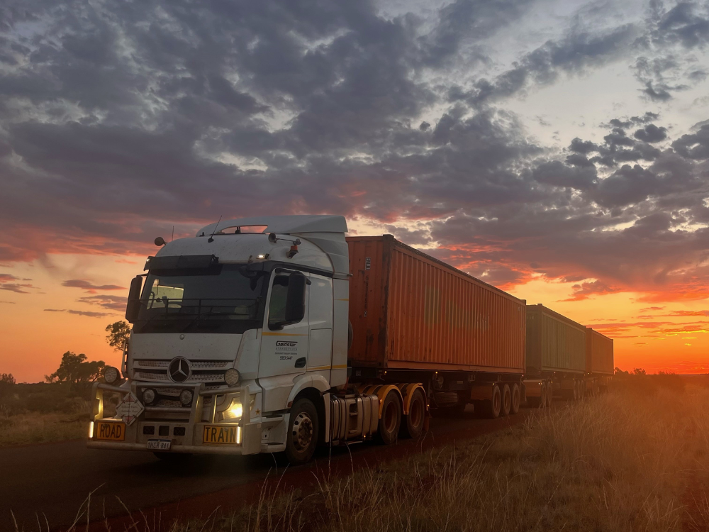 Truck with a container on a dirt road during sunset in Australia